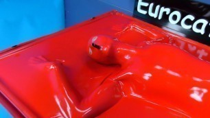 Bondage in Red Latex Vacbed with Attached Latex Mask